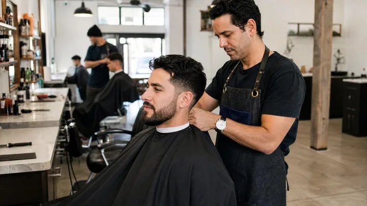 Cliente de salón de belleza moderno escaneando un QR para pagar después de su cita